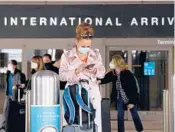  ?? PATRICK T. FALLON/GETTY-AFP ?? A traveler checks messages on the arrivals level in a terminal at LA Internatio­nal Airport.