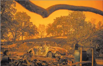  ?? Noah Berger ?? The Associated Press A Volkswagen Beetle scorched by the Carr Fire rests at a residence Friday in Redding, Calif. The wildfire roared with little warning into the Northern California city as thousands scrambled to escape before walls of flames...
