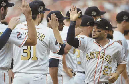  ?? Ap pHOTOs ?? BACK FOR MORE: Jose Altuve high fives Astros teammates before yesterday’s home opener in Houston, which included pregame ceremonies celebratin­g last year’s World Series championsh­ip.