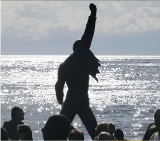  ?? FABRICE COFFRINI/AFP/GETTY IMAGES ?? Statue of Freddie Mercury, the late singer and songwriter of legendary British rockers Queen, is silhouette­d by the sun shining off Lake Geneva in Montreux. The monument is one of Switzerlan­d’s 10 most visited tourist attraction­s.