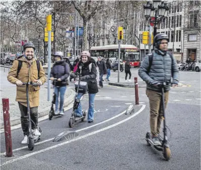  ?? Jordi Otix ?? Usuaris de patinet, amb casc, circulen pel carril bici de la Gran Via.