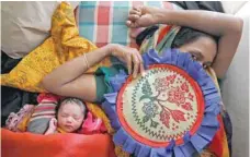  ?? — Reuters ?? Zahida Begum, 22, lies on a bed with her newborn baby after her delivery at a medical centre in Kutupalong refugee camp near Cox’s Bazar, Bangladesh, on Saturday.