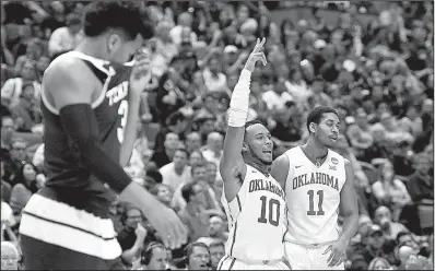  ?? AP/MARK J. TERRILL ?? Oklahoma guard Isaiah Cousins (right) and guard Jordan Woodard (center) celebrate as Texas A&M guard Admon Gilder covers his face during the final moments of Thursday’s game. The Sooners beat the Aggies 77-63 to advance to the Elite Eight for the first...