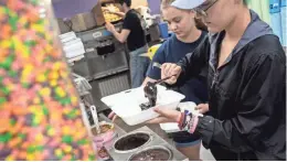  ??  ?? Katie Headley pours fudge onto a treat Thursday while finishing an order inside of Velvet Cream in DeSoto County. Velvet Cream opened for business on July 23, 1947.