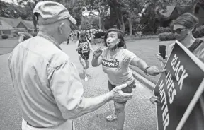  ?? MAX GERSH/THE COMMERCIAL APPEAL ?? Theryn C. Bond, right, points to a sign while trying to get Tim Treadwell to say the words “Black Lives Matter” on Monday while protesting outside of the home of Lloyd Crawford in Germantown.