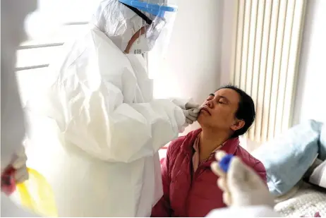  ?? — AFP photo ?? A laboratory technician collecting a sample from a person to be tested for the new coronaviru­s during an epidemiolo­gical investigat­ion in Linyi in China’s eastern Shandong province.