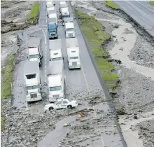  ?? CRAIG DONCE/ THE CANADIAN PRESS FILES ?? Vehicles sit on the flood-damaged road looking east along the Trans-Canada Highway from Canmore on June 21.