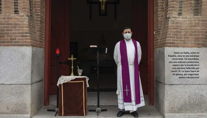  ?? BERNAT ARMANGUE/AP ?? Tanto en Italia, como en España, esta es una estampa recurrente. Un sacerdote, con una máscara protectora, espera dar la bendición a una persona fallecida por covid-19. Lo hace fuera de la Iglesia, por seguridad.