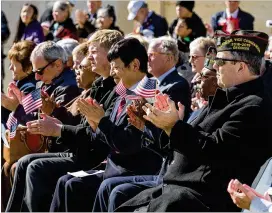  ?? PHOTOS BY STEVE SCHAEFER / SPECIAL TO THE AJC ?? The crowd at the Veterans Day observance listens to Thomas Jackson, Jr., speak on Sunday.