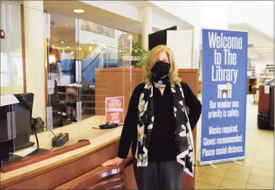  ?? Tyler Sizemore / Hearst Connecticu­t Media ?? Library President Alice Knapp poses by plexiglass windows at the check-out counter at Fergsuon Library in Stamford on Feb. 4. Outside agencies got a cash infusion from the city’s planning board in this year’s budget recommenda­tion, and the Ferguson Library was one of the organizati­ons to reap the benefit.