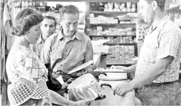  ??  ?? Erich and Erna Benjamin, Joe Benjamin’s parents, examine new kitchenwar­e at Sosua’s general store with Max Blum, right, the writer’s uncle.