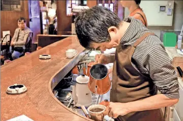 ??  ?? A barista of coffee shop Cafe de L’Ambre brewing a cup of coffee in Tokyo’s fashion district Ginza.