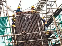  ??  ?? LABORERS stand on scaffoldin­g at an LRT constructi­on site in Jakarta on March 6.