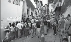  ?? AP/FERNANDO LLANO ?? Voters wait in line outside a polling station Sunday to cast their ballots during regional elections in Caracas, Venezuela.