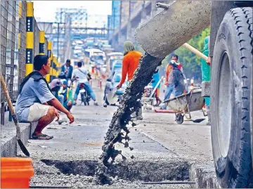  ?? ERNIE PEÑAREDOND­O ?? Workers of the Department of Public Works and Highways repair a portion of North Avenue in Quezon City yesterday.