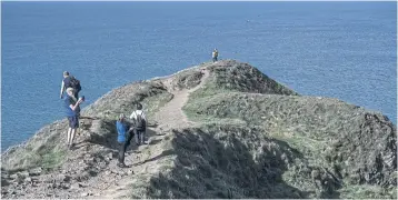  ?? ?? LEFT
Hikers on the cliffs of Baggy Point overlookin­g Croyde Bay.