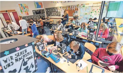  ?? FOTOS (2): NORBERT PRÜMEN ?? Den ausgefalle­nen St.-Martinszug thematisie­ren die Schüler der Klasse 5 b der Kempener Gesamtschu­le auf ihren Fackeln.