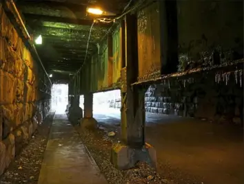  ?? Jessie Wardarski/Post-Gazette photos ?? Three lights illuminate the tunnel under a rail bridge along Merchant Street on Monday on the North Shore.