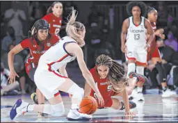  ?? Tim Aylen
The Associated Press ?? South Carolina’s Victaria Saxton
(5), right, guard Destanni Henderson (3), left, and Connecticu­t guard Paige Bueckers (5) fight for ball possession during the final of the Battle 4 Atlantis tournament in the Bahamas.