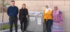  ??  ?? GU-Q’s Sustainabi­lity Club members with the machine that converts food waste into nutrient-rich soil.