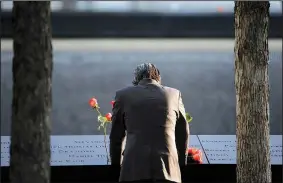  ?? AP/SETH WENIG ?? A man stands at the edge of a waterfall pool at ground zero during a ceremony on the 16th anniversar­y of the 9/11 attacks Monday in New York.
