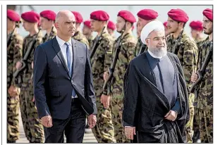  ?? AP/PETER KLAUNZER ?? Swiss Federal Council President Alain Berset and Iranian President Hassan Rouhani review an honor guard Monday in Zurich. Rouhani said if the U.S. gets its allies to stop buying Iranian oil, that could also jeopardize Mideast oil exports.