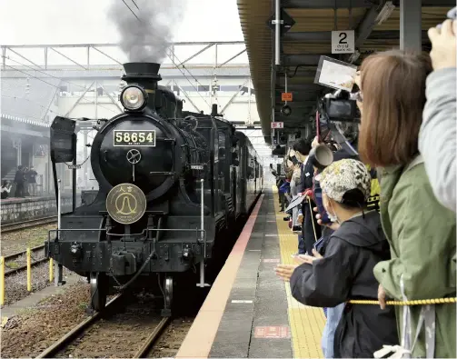  ?? The Yomiuri Shimbun ?? Locomotive No. 58654 is welcomed by fans as it arrives in JR Yatsushiro Station in Kumamoto Prefecture on Nov. 18.