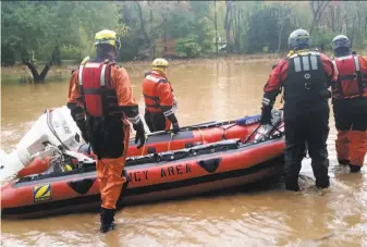  ?? Philip A. Holmes / Williamspo­rt (Pa.) Sun-Gazette ?? A rescue team in Trout Run, Pa., heads out to help volunteer firefighte­rs whose boat became snagged Friday in flood debris and deflated. A storm in the area dumped up to 7 inches of rain.