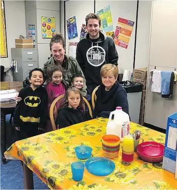  ??  ?? Lisha De-Vries, Evan Klaassen and Susan M’Gonigle, seated, serve breakfast to students at Rock City Elementary in Nanaimo, “a pretty poor city,” where low-income families number 22.7 per cent, says M’Gonigle.