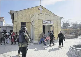  ?? AFP ?? Security personnel rescue a woman after the attack on Quetta’s Bethel Memorial Methodist Church.