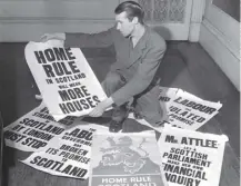  ??  ?? 0 A man with Home Rule posters after nationalis­ts seized the Stone of Destiny; it was regained today in 1951