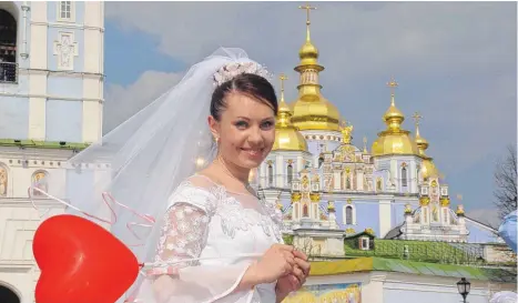  ?? FOTO: DETLEF BERG ?? Als Frischverm­ählte grüßen Brautleute gerne vor den goldenen Kuppeln der Michaelkir­che.