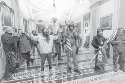  ?? MANUELBALC­E CENETA/AP ?? Supporters of President Donald Trump slow their march to the Senate chamber after being confronted by U.S. Capitol Police officers last week. At least five people died in the chaos, including an officer, as rioters stormed the building in Washington.