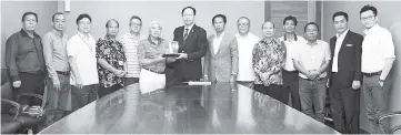  ??  ?? Teo (seventh left) receiving a souvenir from Lee while Limus (seventh right), Fung (left),Yeo (second left), Chang (fifth right) and others look on.