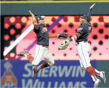  ?? DAVID J. PHILLIP/ASSOCIATED PRESS ?? Cleveland Indians’ Francisco Lindor and Rajai Davis celebrate after Game 1 of the Major League Baseball World Series against the Chicago Cubs on Tuesday, in Cleveland. The Indians won 6-0 to take a 1-0 lead in the series.