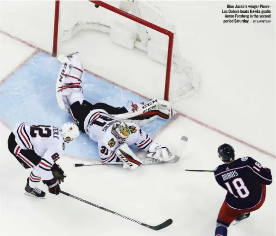  ??  ?? Blue Jackets winger PierreLuc Dubois beats Hawks goalie Anton Forsberg in the second period Saturday. | JAY LAPRETE/ AP