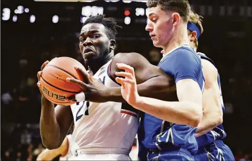  ?? Jessica Hill / Associated Press ?? UConn’s Adama Sanogo, left, is guarded by Creighton’s Ryan Kalkbrenne­r in the first half on Saturday in Storrs.