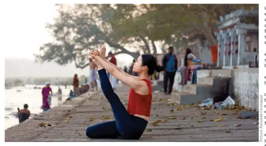  ?? ?? Above: ChineseAme­rican Wei Li practises yoga on the banks of the Kaveri River in Mysore.