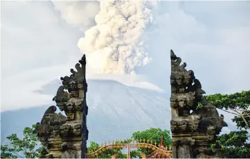  ??  ?? A general view shows Mount Agung erupting between Balinese temple seen at night from Kubu sub-district in Karangasem Regency on Indonesia’s resort island of Bali. — AFP photo