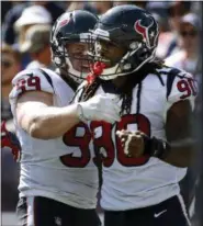  ?? MICHAEL DWYER - THE ASSOCIATED PRESS ?? FILE - In this Sept. 24, 2017, file photo, Houston Texans linebacker Jadeveon Clowney, right, celebrates his touchdown with J.J. Watt, left, after recovering a fumble by New England Patriots quarterbac­k Tom Brady during the first half of an NFL football game in Foxborough, Mass. Here’s a crazy thought: The Houston Texans with homefield advantage throughout the AFC playoffs. Yep, the team that began the season 0-3just might sneak past the Chiefs and Patriots and claim that coveted spot.