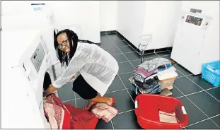  ?? Picture: BRIAN WITBOOI ?? GOING GREEN: The Spin Cycle laundry owner Michiko Mavunga gets down to business at her commercial laundromat’s Newton Park premises