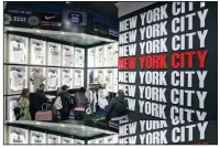  ?? ?? People shop at a Times Square souvenir and sports apparel store last week in New York City. (AP/Seth Wenig)