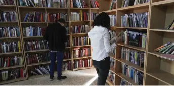  ?? ?? Members of the Kurdistan Centre for Arts and Culture (KCAC), select old books from the shelves before making digital copies, as part of an effort to digitise historic Kurdish volumes and manuscript­s, in the northern Iraqi city of Dohuk.