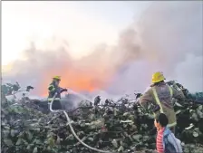  ??  ?? Momento en que un grupo de bomberos trabajaba arduamente para apagar el fuego en el basural.