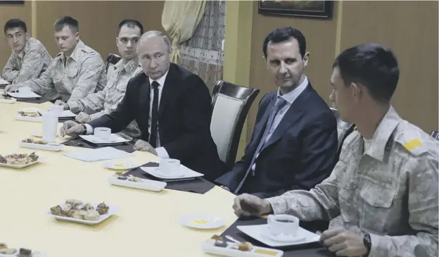  ?? PICTURE: AP ?? 0 Russian President Vladimir Putin, centre left, and Syrian President Bashar Assad, second right, meet with military personnel yesterday.