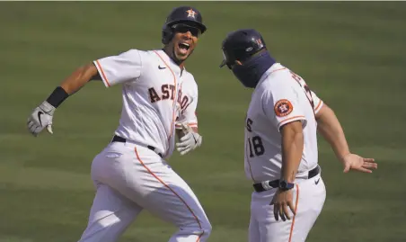  ?? Marcio Jose Sanchez / Associated Press ?? Houston’s Michael Brantley ( left) celebrates with firstbase coach Omar Lopez after hitting a solo home run against the A’s in the fifth inning. Brantley had two homers in the game. Below, Carlos Correa exults after his threerun shot in the fourth.