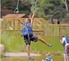  ??  ?? Waylen Aguino, 11, of Ohkay Owingeh crosses the rings over a pond Saturday at Glorieta Camps.