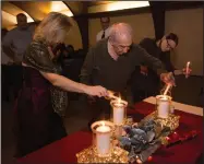  ??  ?? Community members lit candles in honor of loved ones.