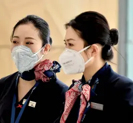  ??  ?? China Eastern Airlines aircrew arrive at Sydney airport after landing on a plane from Shanghai on January 25. Australian authoritie­s confirmed its first case of a new virus as thousands of people worldwide are treated for the deadly infection (Photo by PETER PARKS / AFP)