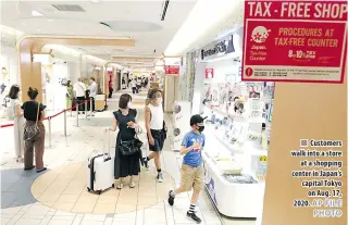  ?? AP FILE PHOTO ?? Customers walk into a store at a shopping center in Japan’s capital Tokyo on Aug. 17, 2020.